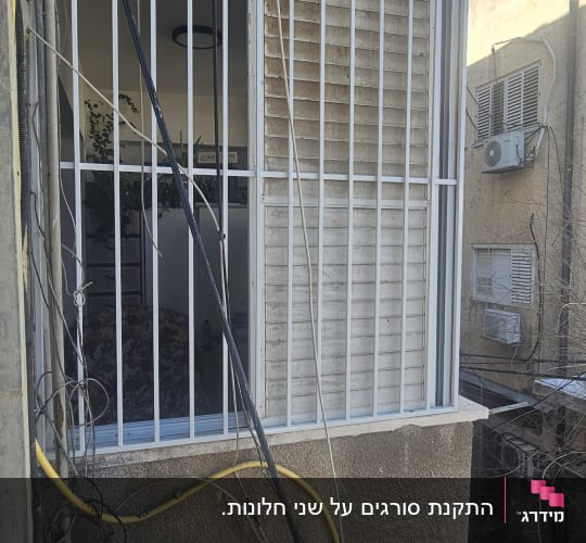 סורגים מותקנים על חלון חיצוני עם חוטי חשמל מסביב